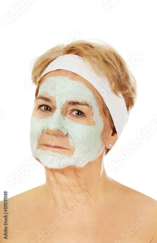 Relaxed elderly woman in facial mask