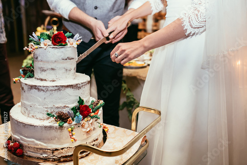 bride and groom cut rustic wedding cake on wedding banquet with