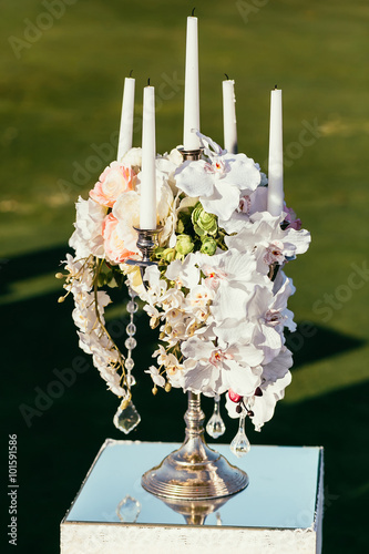 wedding decoration with flowers and candle on sunny day in cerem photo