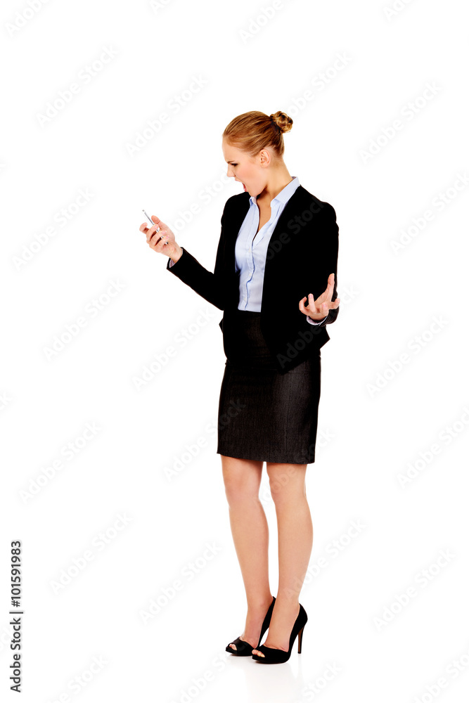 Angry business woman yelling to the mobile phone