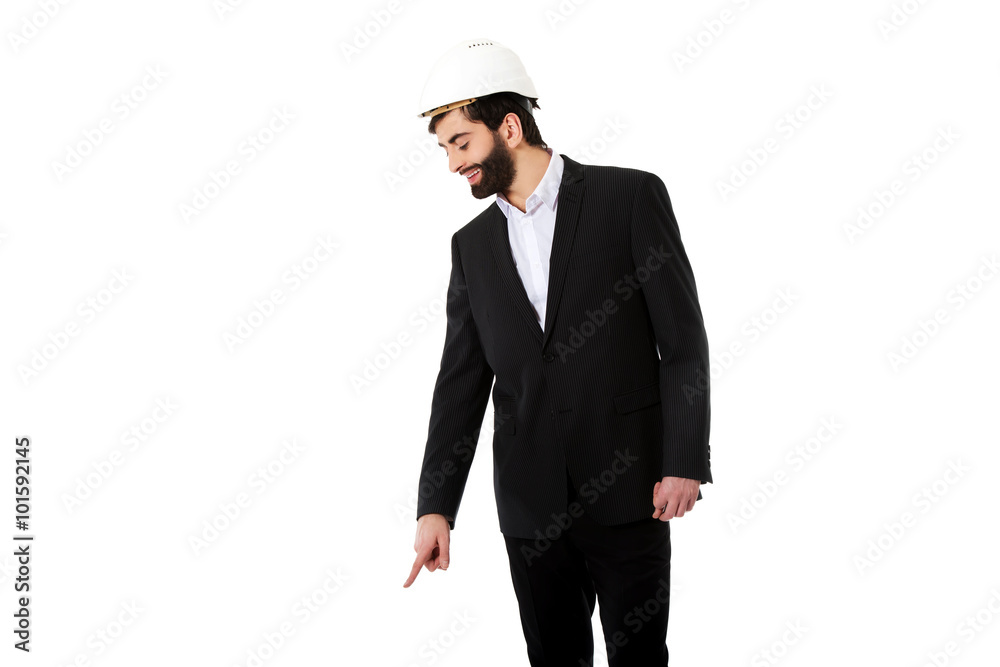 Engineer in protective helmet pointing down. Engineer in protective helmet pointing down.