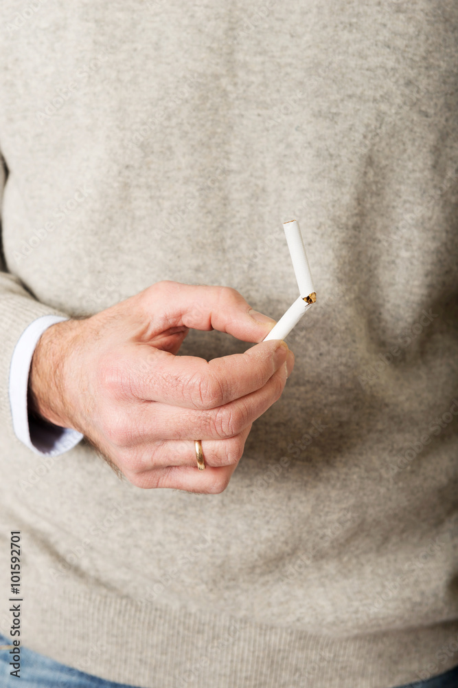 Naklejka premium Male hand with broken cigarette