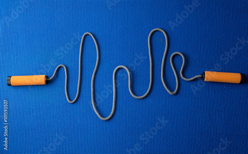 Cardiogram from jumping rope on blue yoga mat background