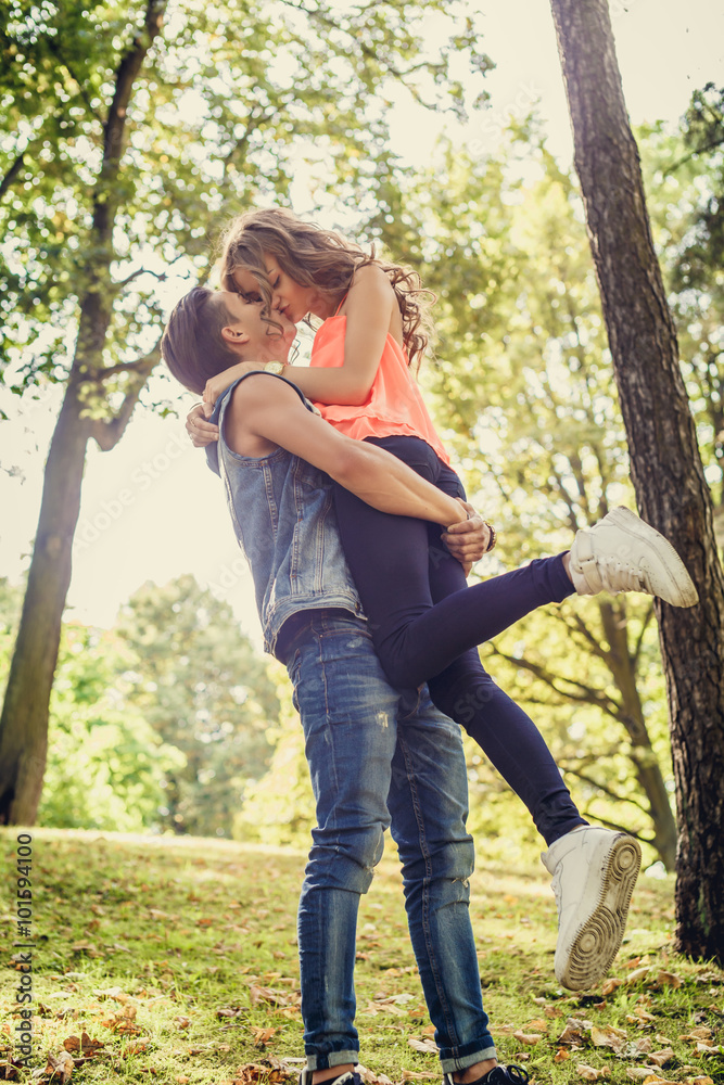 Young couple kissing in a park. Young couple kissing in a park.