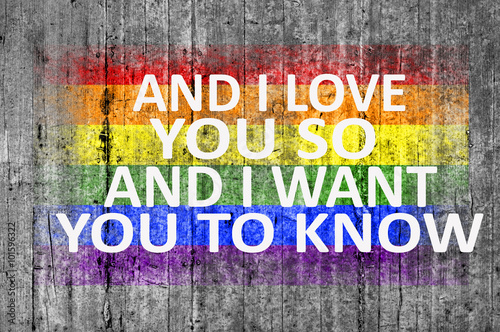 And I love you so, and I want you to know and LGBT flag painted on background texture gray concrete