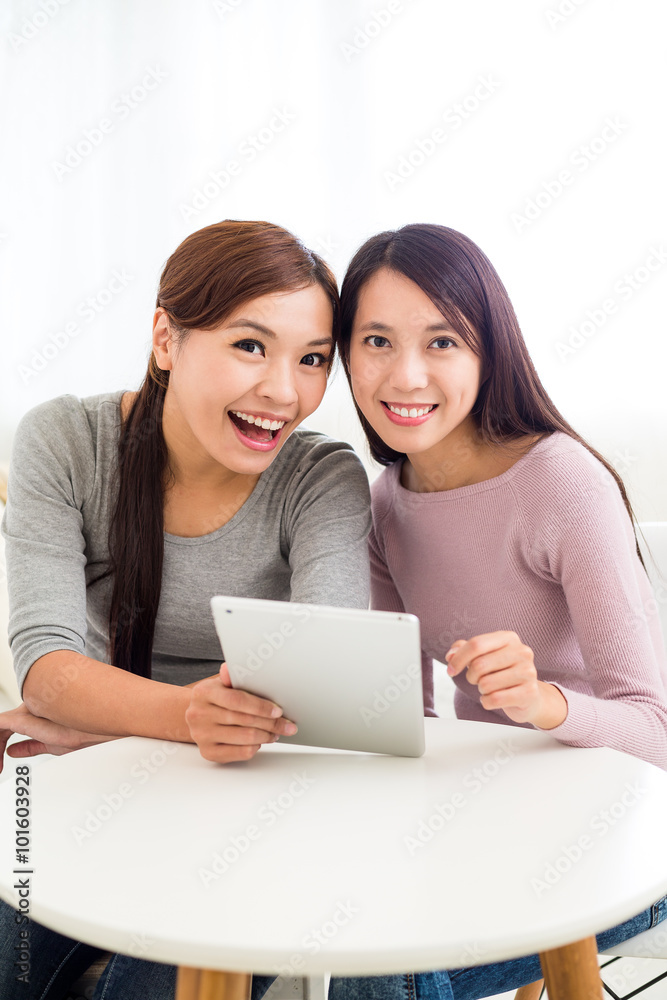 Two girls use of the tablet pc together Two girls use of the tablet pc together