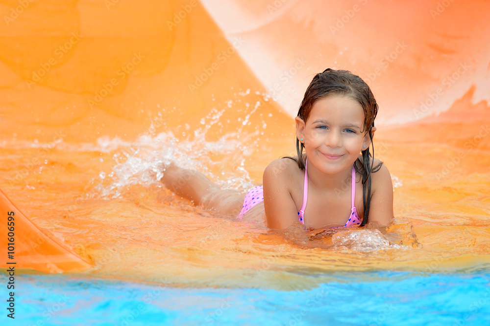 Adorable toddler girl on water slide at aquapark Adorable toddler girl on water slide at aquapark