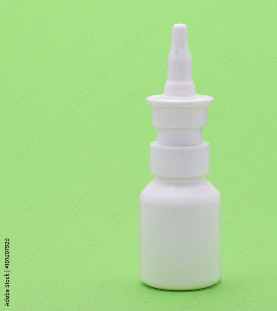 Nasenspray in der Weißen Plastikflasche isoliert auf grünem Hintergrund Nasenspray in der Weißen Plastikflasche isoliert auf grünem Hintergrund