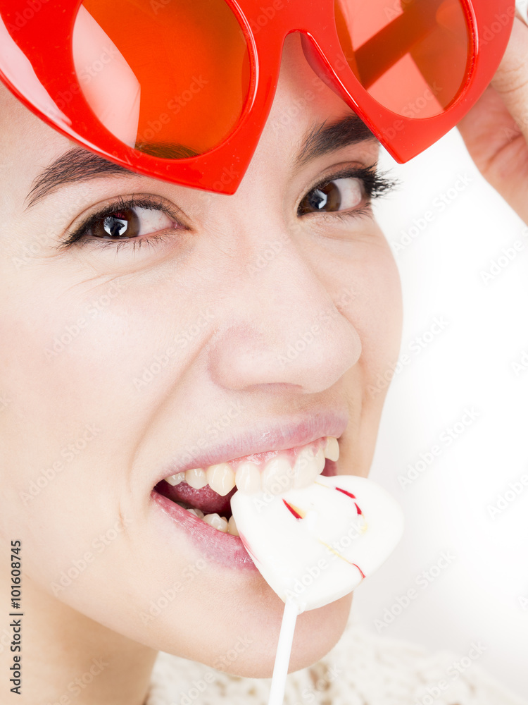 Φωτογραφία Valentine's day portrait of an attractive young brunette girl with heart shaped glasses and heart shaped lollipop