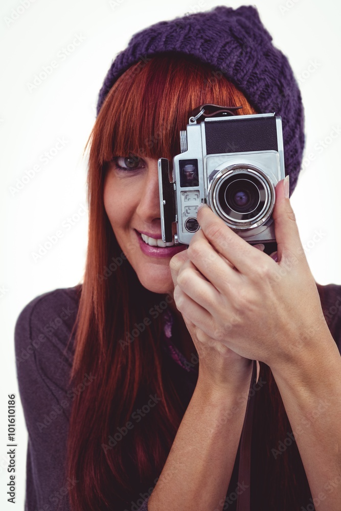 Smiling hipster woman taking pictures with a retro camera Smiling hipster woman taking pictures with a retro camera