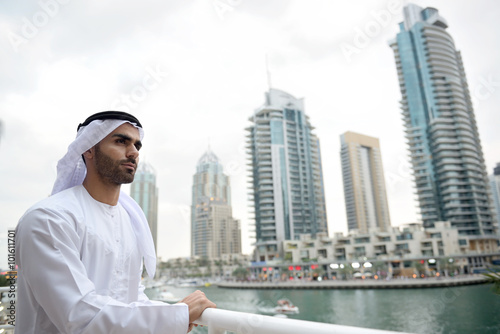 Young Emirati man standing by the canal in Dubai Marina, UAE