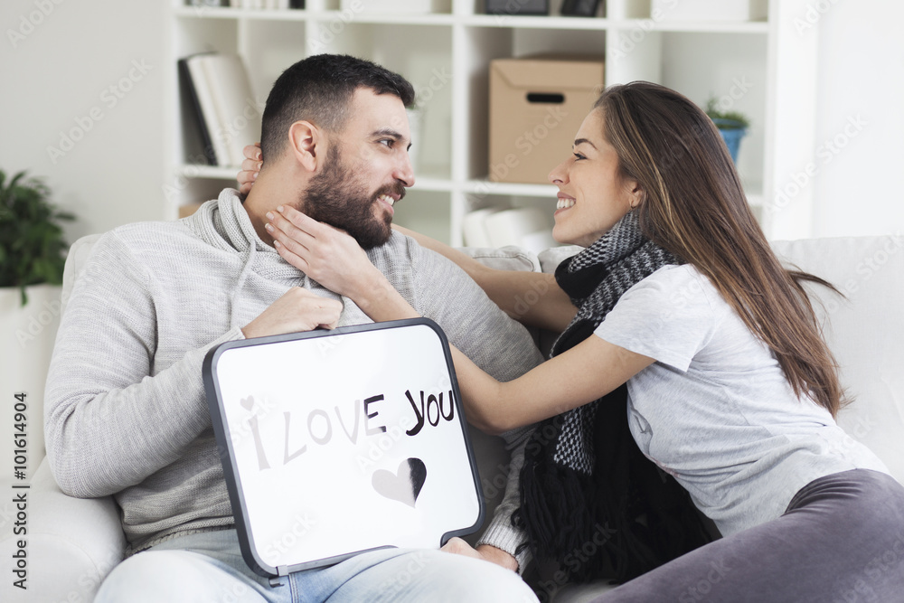Young couple showing love message written on white board. I love you message. Valentines couple,shallow depth of filed Young couple showing love message written on white board. I love you message. Valentines couple,shallow depth of filed