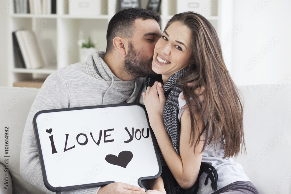 Fotografie Young couple showing love message written on white board