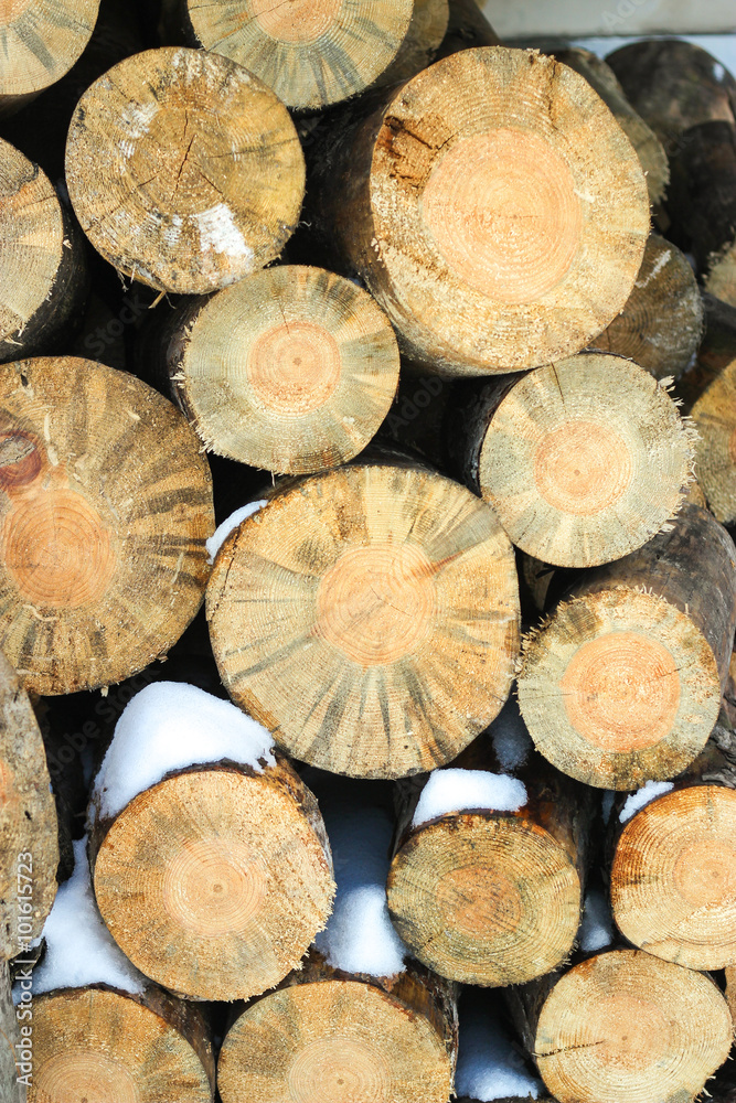 wooden logs, stacked one upon the other sprinkled with snow. wooden logs, stacked one upon the other sprinkled with snow.
