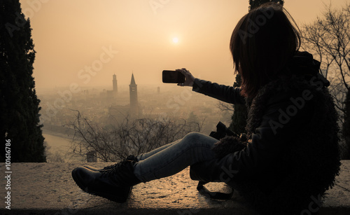 Girl is taking a selfie with her smartphone on a urban landscape - caucasian people - concept about people, landscape, technology and lifestyle photo