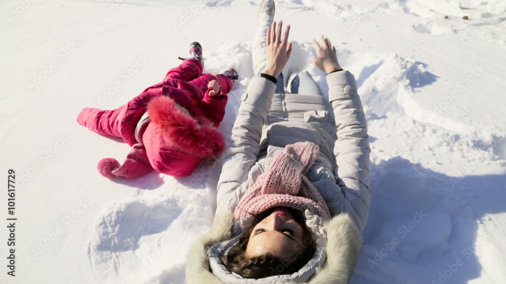 mother and daughter having fun on the snow slow motion