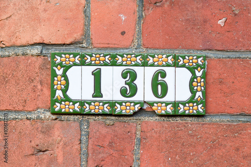 House number 136 sign on painted tiles