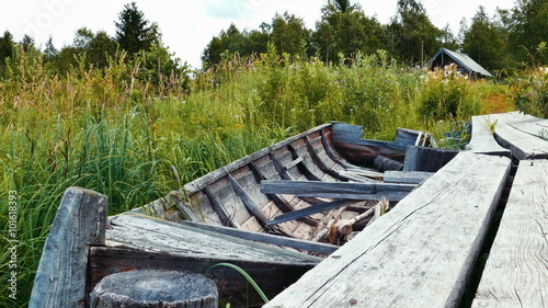 Obsolete woden vessel boat neas pier at lake shore photo
