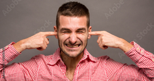 Man covering his ears
