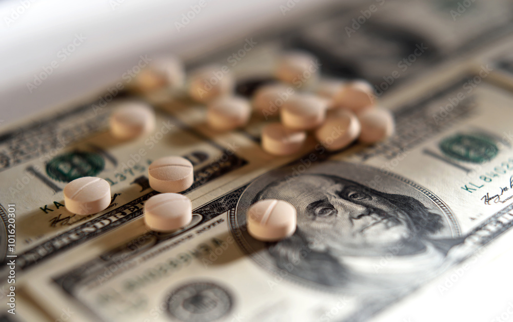 Tablets on dollar bills (treatment, addiction, aging - concept).