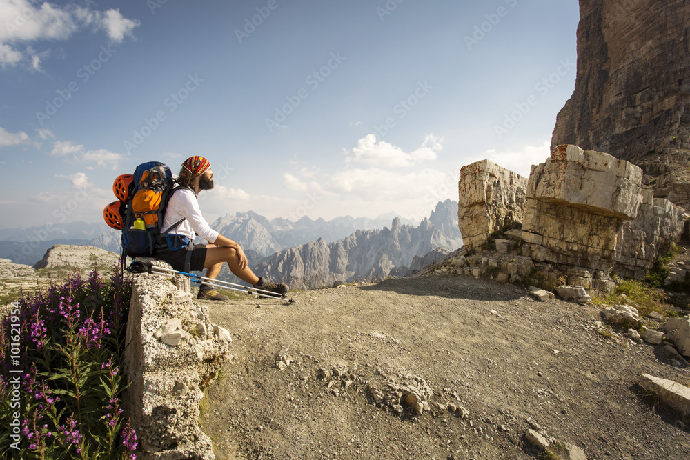Man with big bag for trekking relaxing at National Park Tre Cime