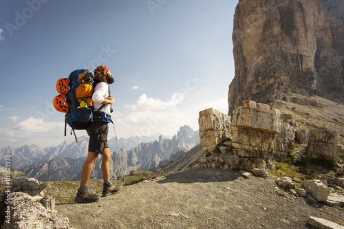 Man with big bag for trekking relaxing at National Park Tre Cime