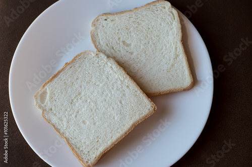 2 slices of white bread on a white plate