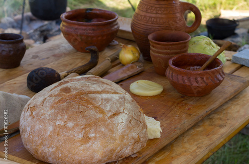 Ancient wooden and clay dishes with bread on a table