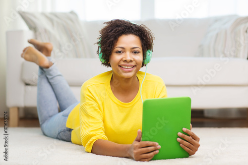 happy african woman with tablet pc and headphones