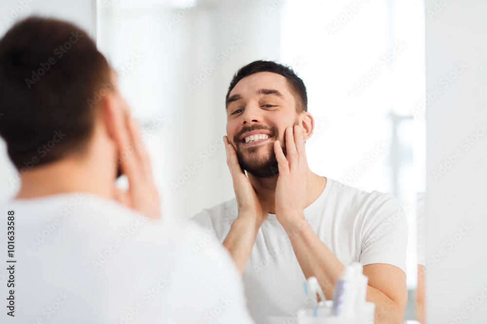 happy young man looking to mirror at home bathroom happy young man looking to mirror at home bathroom