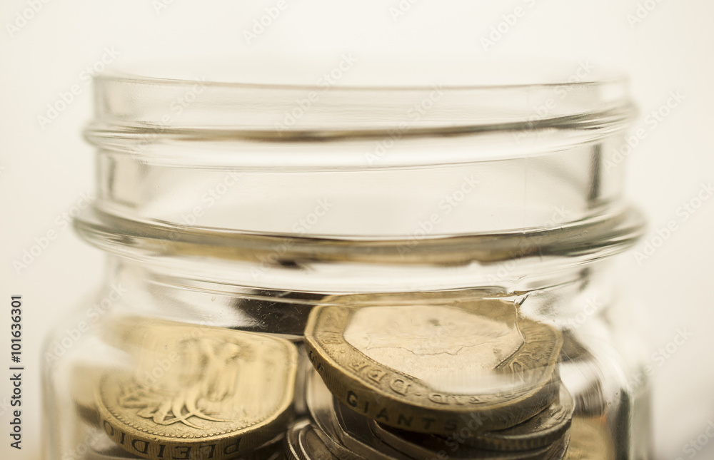 Soft focus stack of coins in glass jar Soft focus stack of coins in glass jar