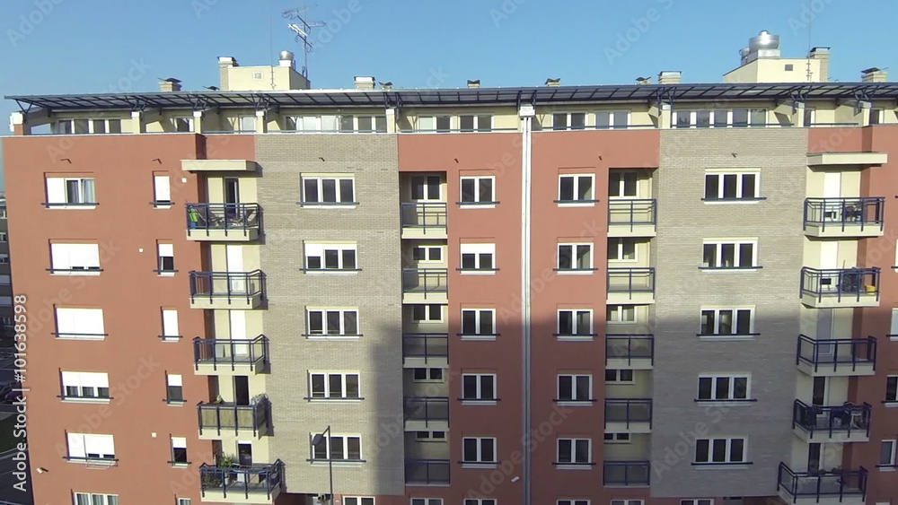 Aerial of new buildings, lots of windows and balconies and terraces. Brick facade, glass on the windows and sun glare Aerial of new buildings, lots of windows and balconies and terraces. Brick facade, glass on the windows and sun glare