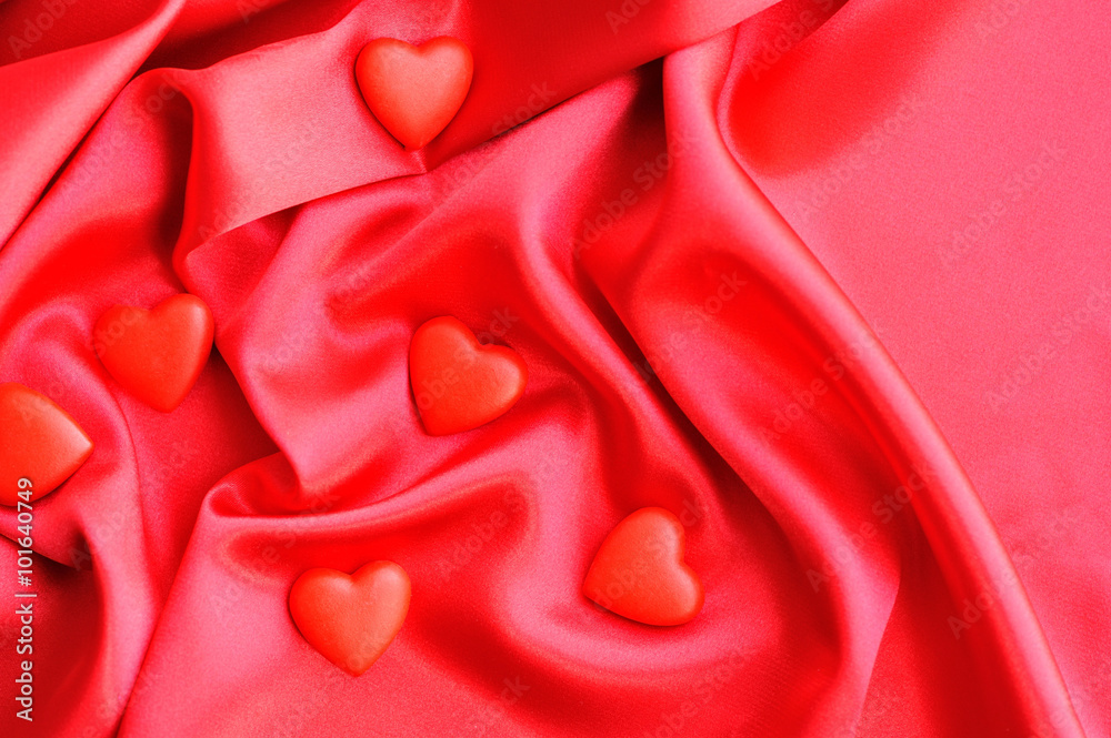 Red hearts on satin fabric background Red hearts on satin fabric background