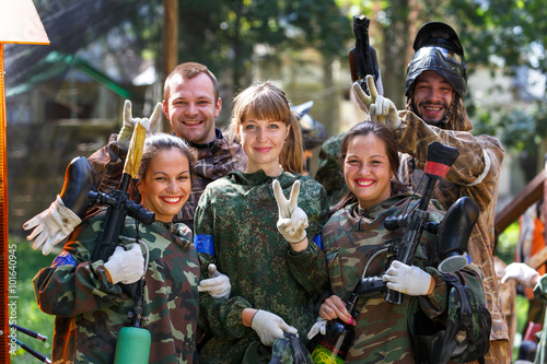 Happy team of five paintball players outdoors photo