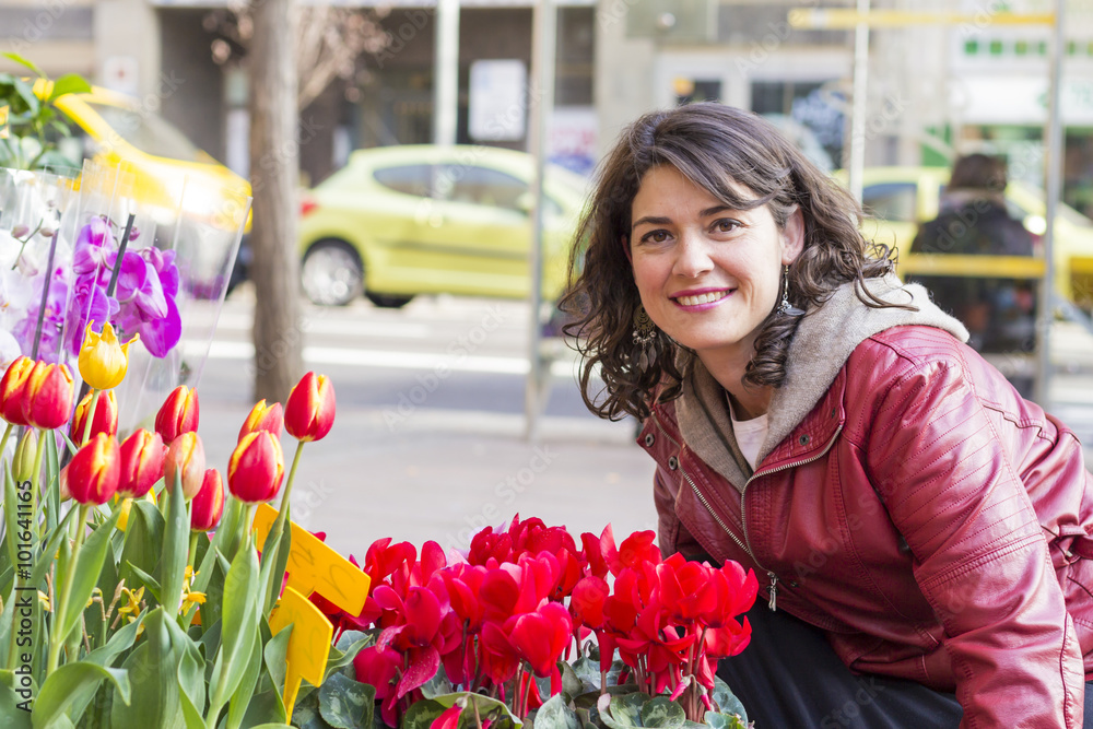 Fototapeta premium Beautiful woman looking flowers at market..