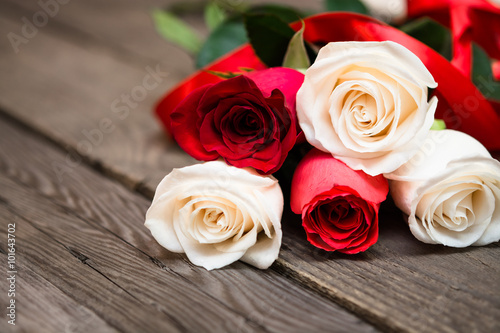 Red and white roses on a dark wooden background. Women  s day  V
