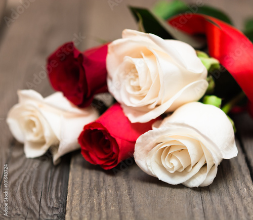 Red and white roses on a dark wooden background. Women  s day  V