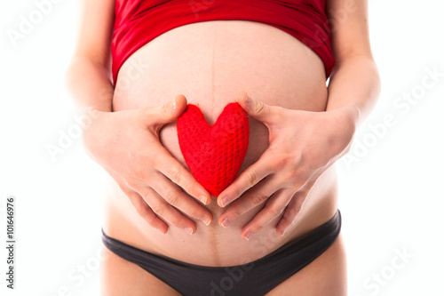 Wallpaper Mural pregnant woman's belly with red knitted heart, concept of  love, Torontodigital.ca