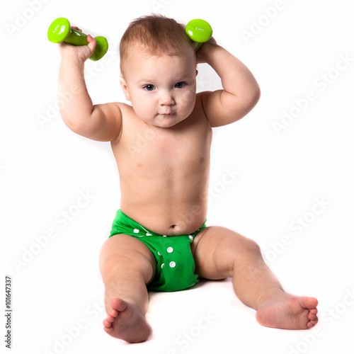 baby kid, toddler in green diapers  doing exercises with dumbbel photo