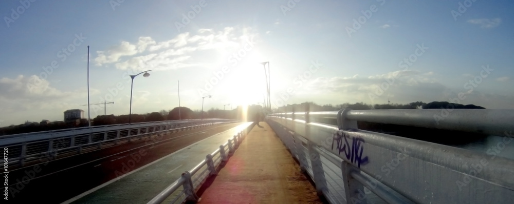 Panoramic view of a bridge that is backlit at dawn