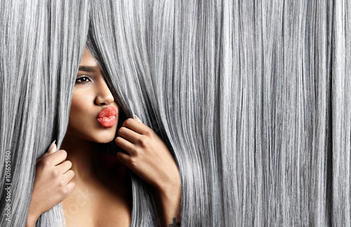 woman look out throught grey hair and sending a kiss photo
