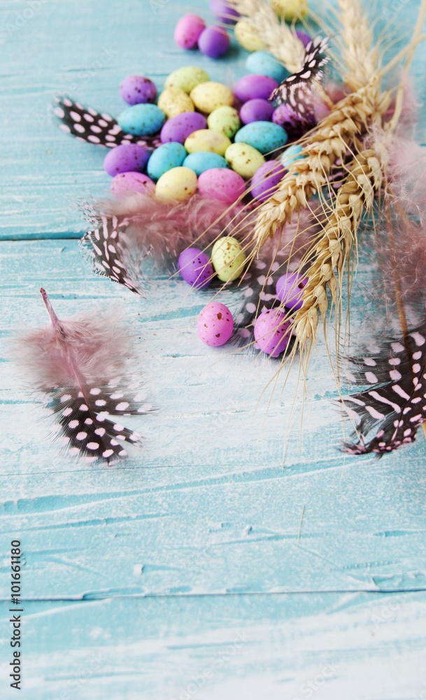 Easter colored eggs, feathers, blue wooden Easter colored eggs, feathers, blue wooden