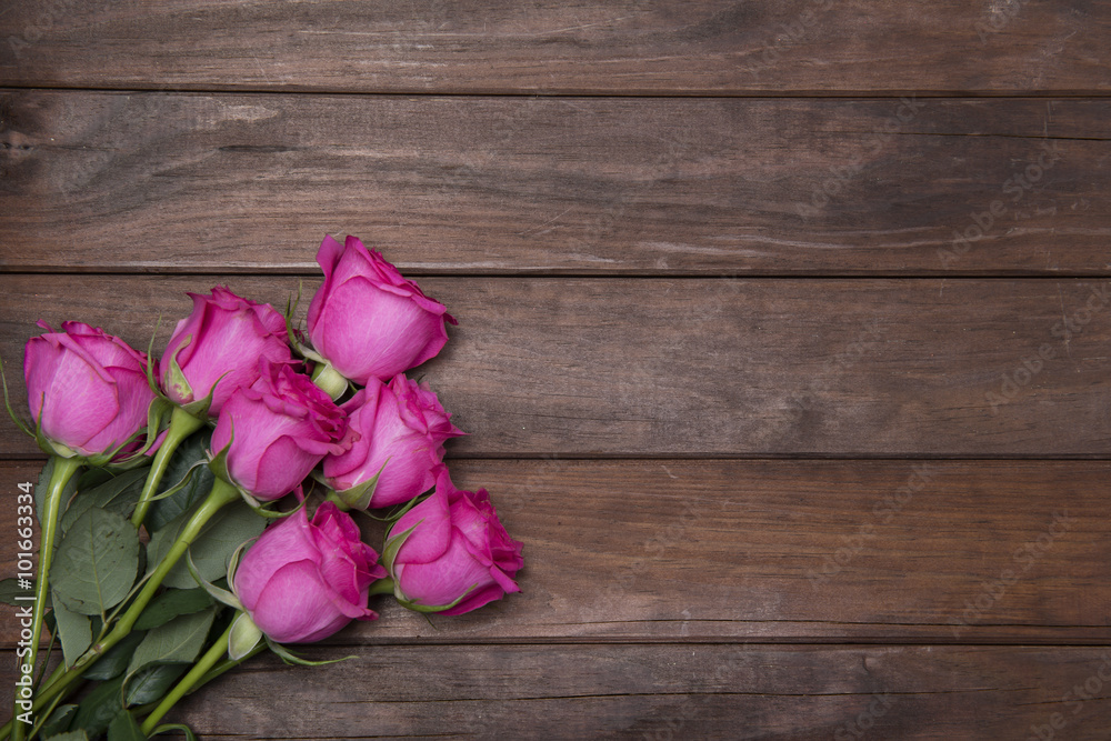 beautiful fresh roses on wooden background