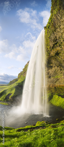 Fototapeta Naklejka Na Ścianę i Meble -  vertical panorama with waterfall and green grass in Iceland
