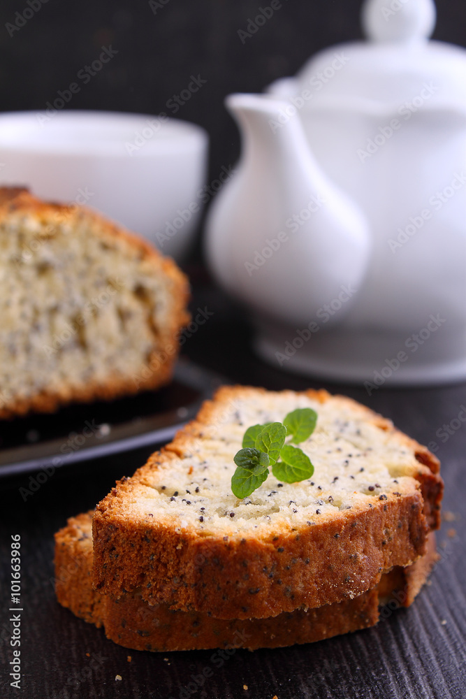 sweet citrus cake with poppy seeds and icing on a dark background sweet citrus cake with poppy seeds and icing on a dark background