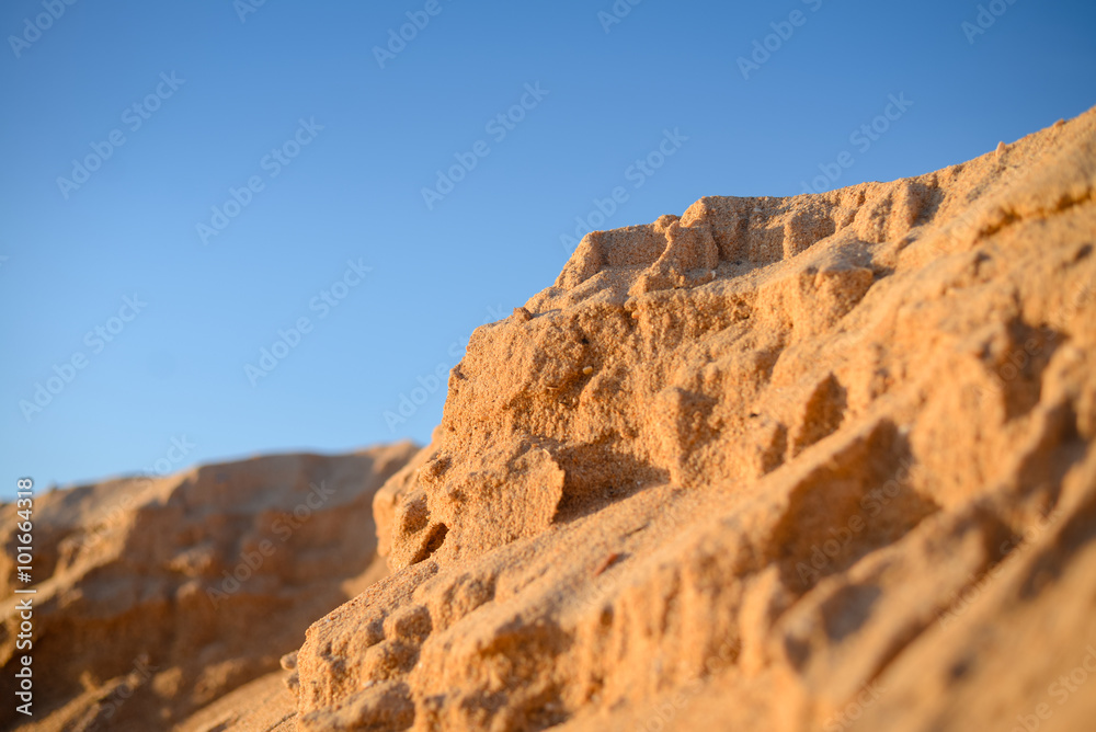 Desert, sandy barkhans over background of blue sky 