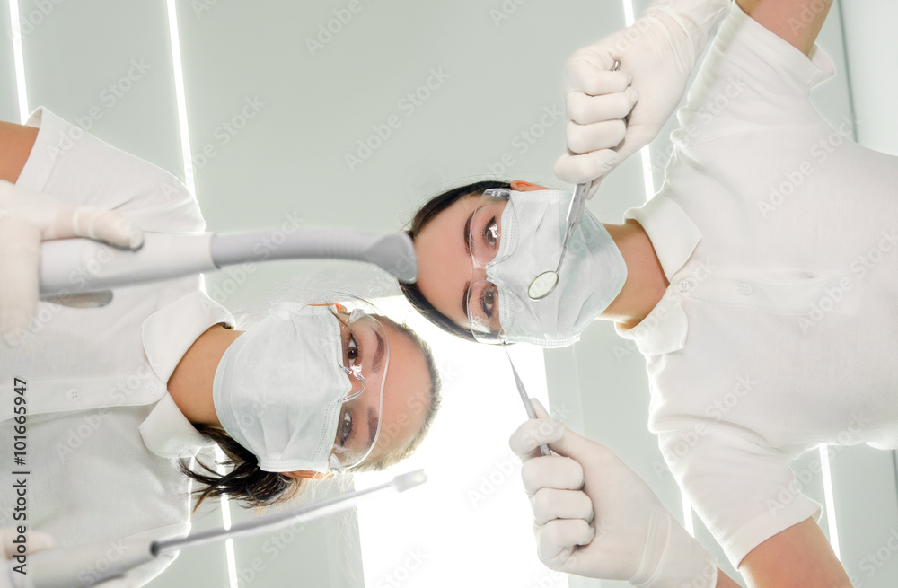 Naklejka premium Portrait of dentist and his assistant the patient's eye view from low