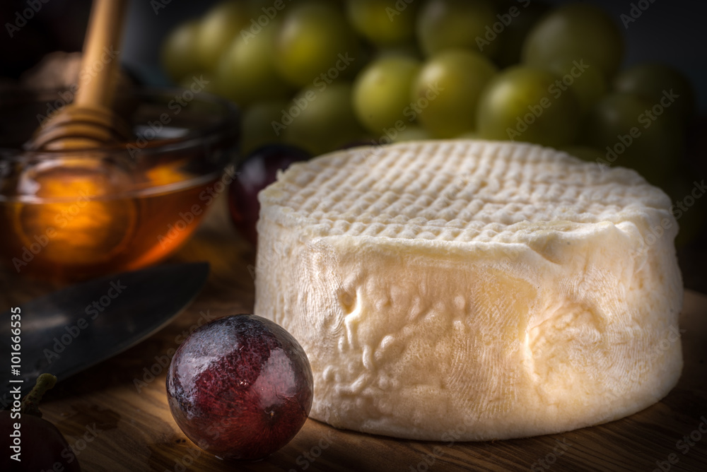 Fototapeta premium wooden board with cheeses, grapes, nuts and honey light paint