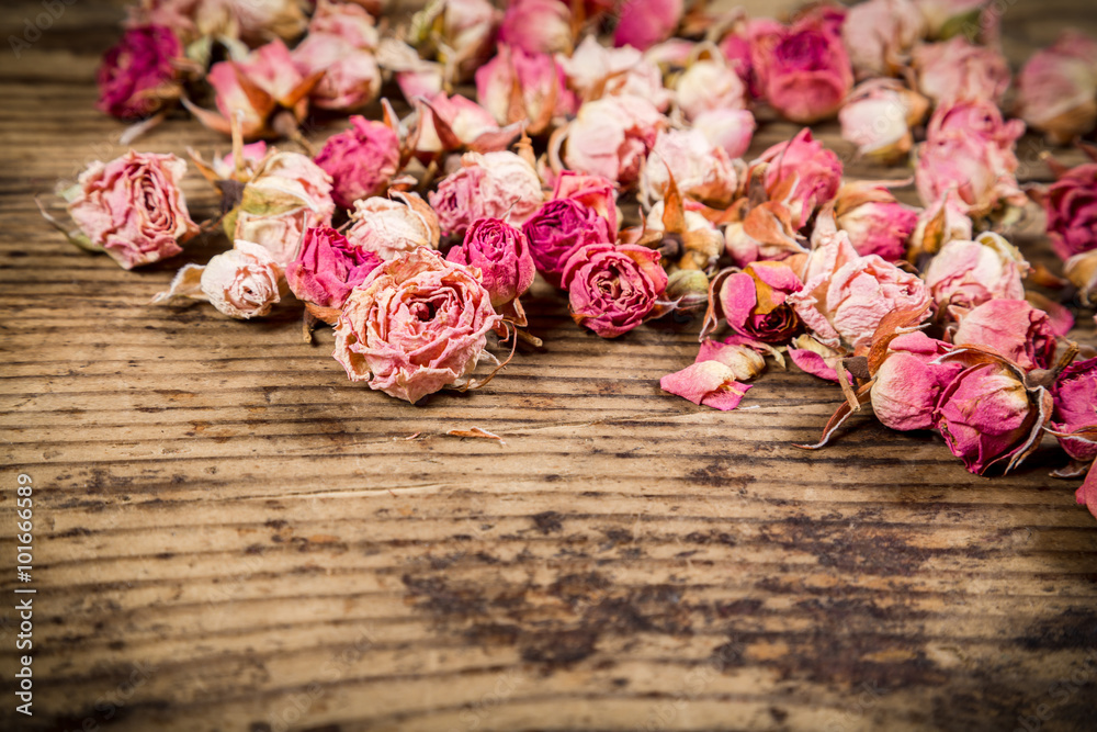 Closeup of dried roses on wooden background - obrazy, fototapety, plakaty 