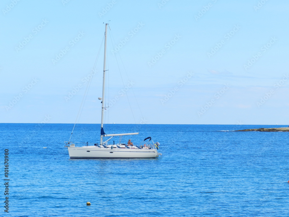 Парусная лодка в море на фоне горизонта 
